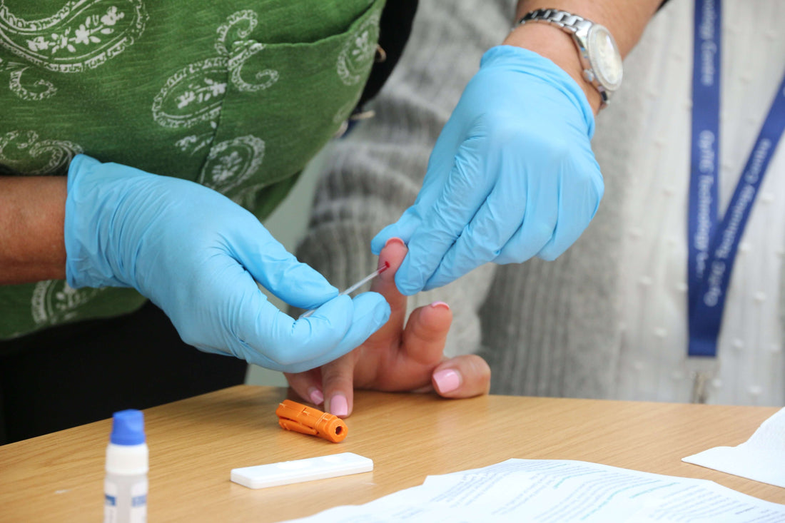 Nurse performing a blood test to check ferritin levels using a SELFCHECK Iron Level Test for iron deficiency anaemia